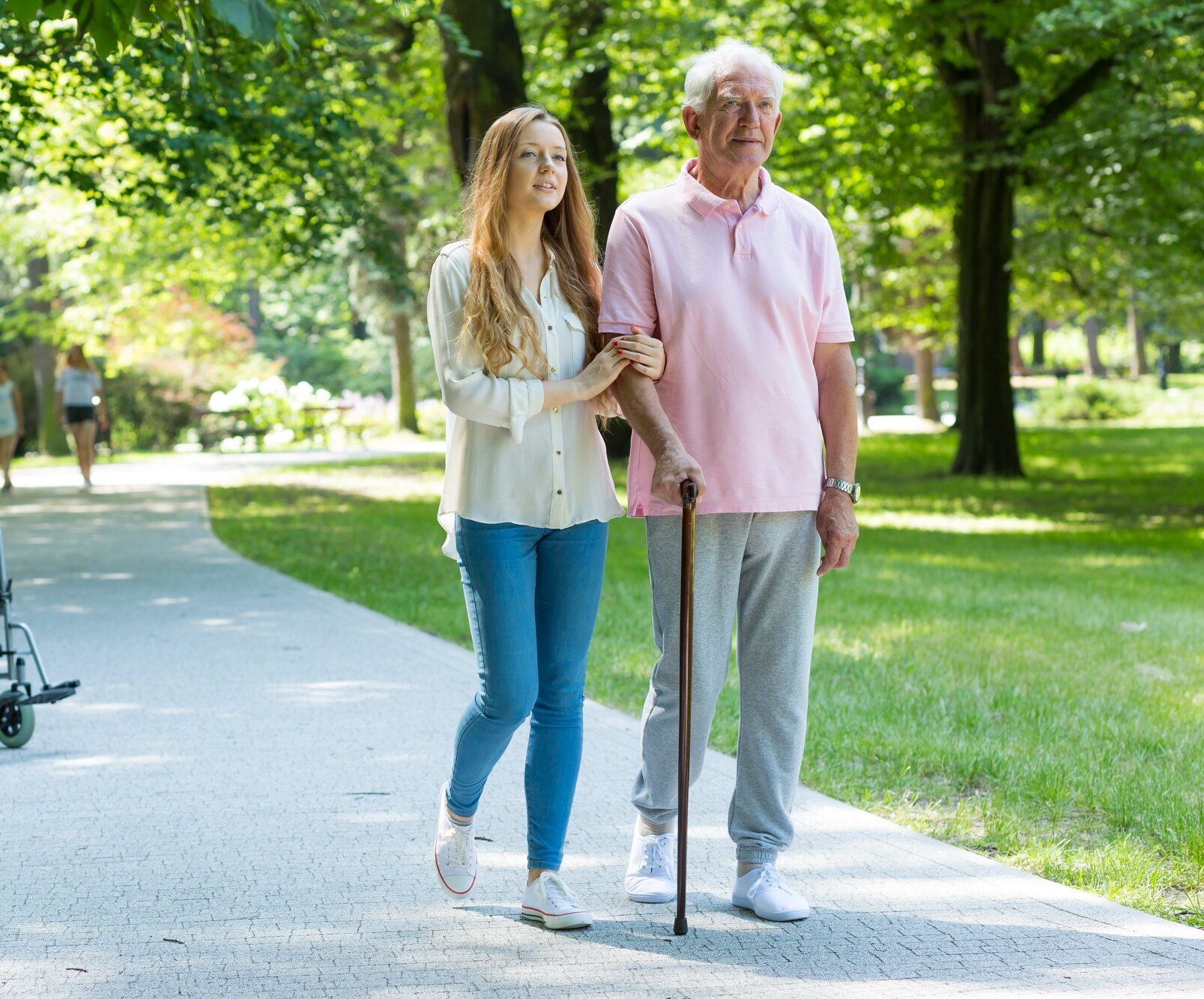 Woman helping elderly man with cane