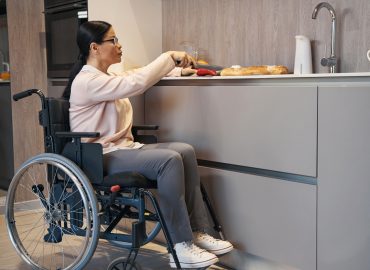 Mature woman with paraleria cooking in kitchen